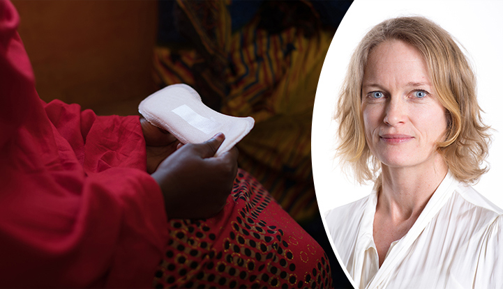 A young African woman holding a menstrual pad.